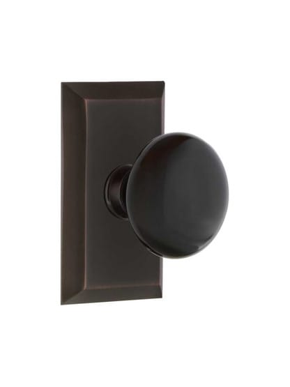 New York Rosette Door Set with Black Porcelain Knobs in Timeless Bronze.